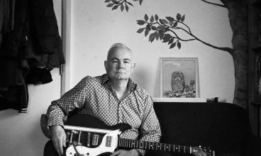 b&w photo DAVID LANCE CALLAHAN seated on small sofa - credit James Fry